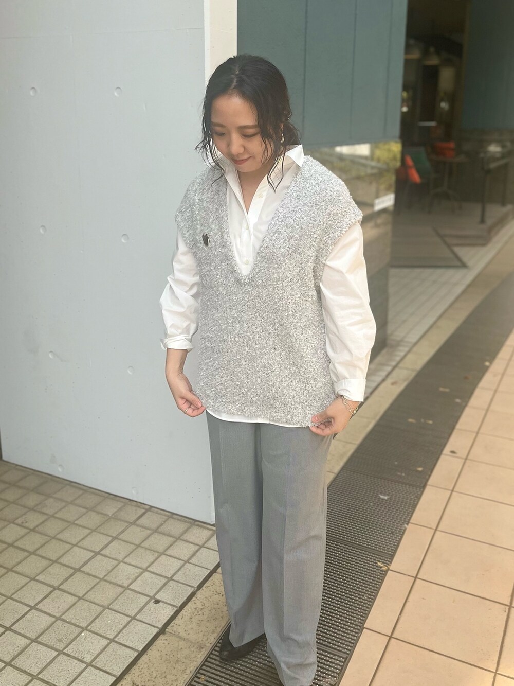 グレー系のベスト、ホワイト系のシャツ/ブラウス、グレー系のその他パンツを着用したレディースの冬コーディネートの5枚目の写真