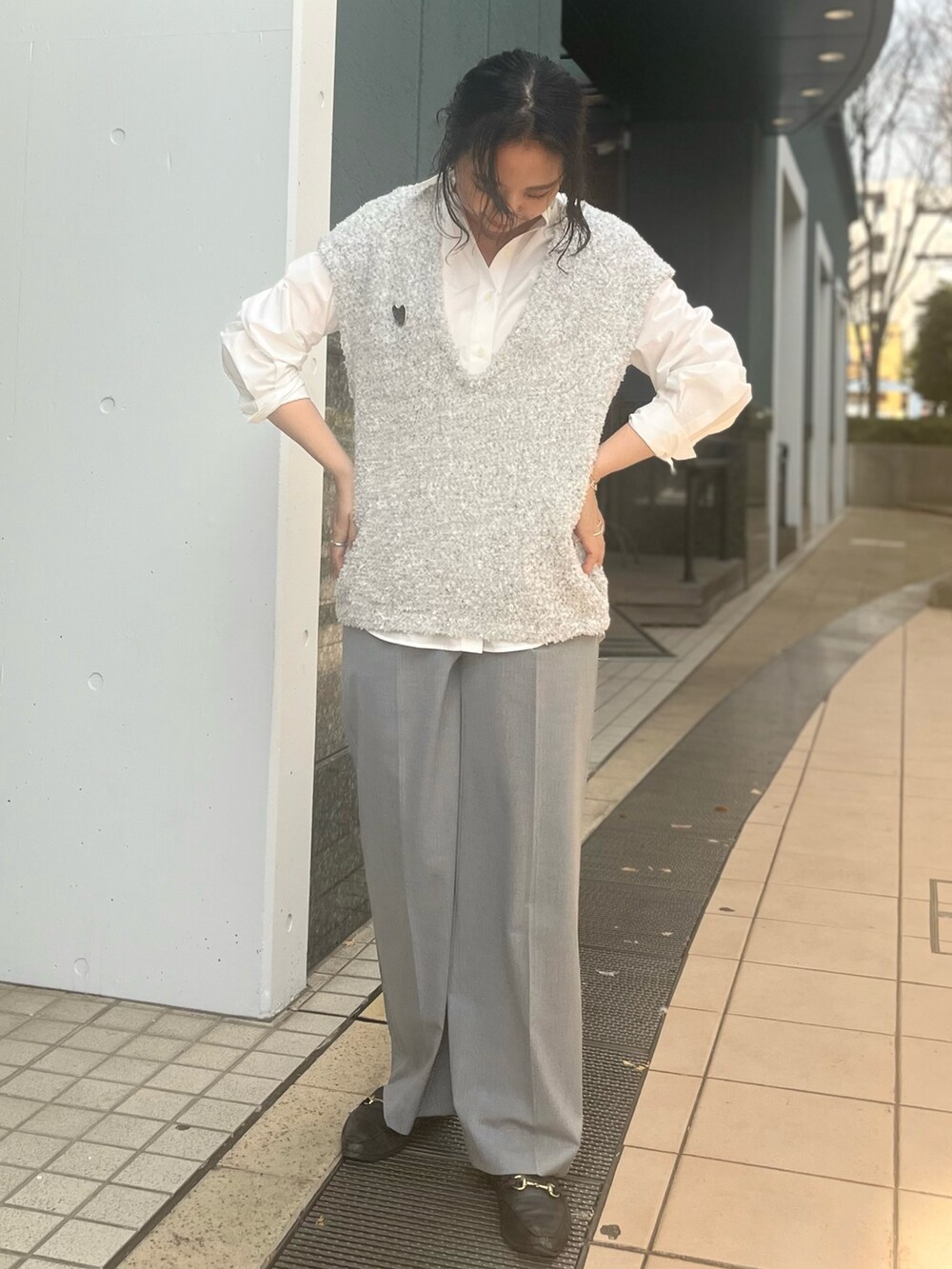 グレー系のベスト、ホワイト系のシャツ/ブラウス、グレー系のその他パンツを着用したレディースの冬コーディネートの3枚目の写真