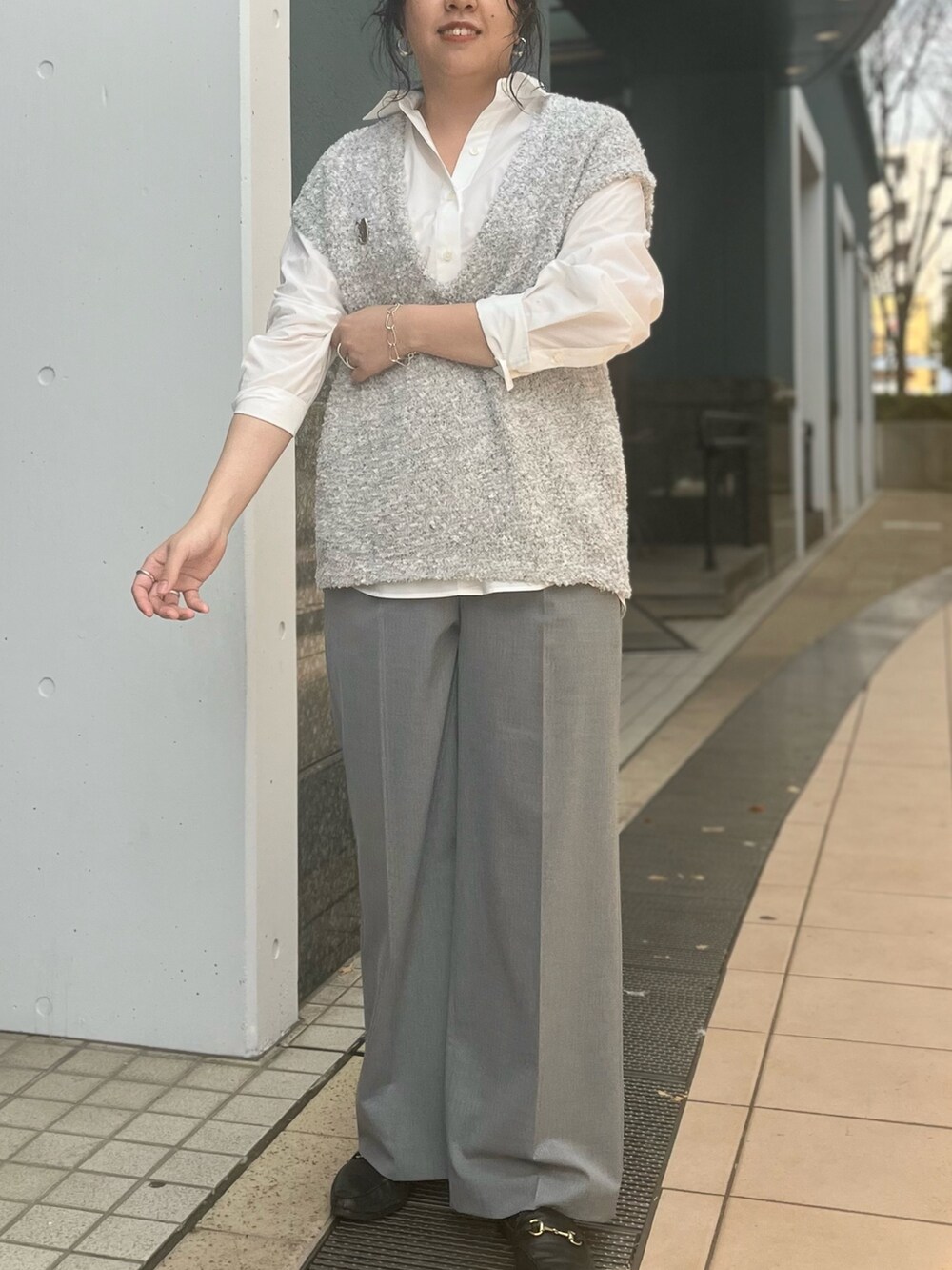 グレー系のベスト、ホワイト系のシャツ/ブラウス、グレー系のその他パンツを着用したレディースの冬コーディネートの4枚目の写真
