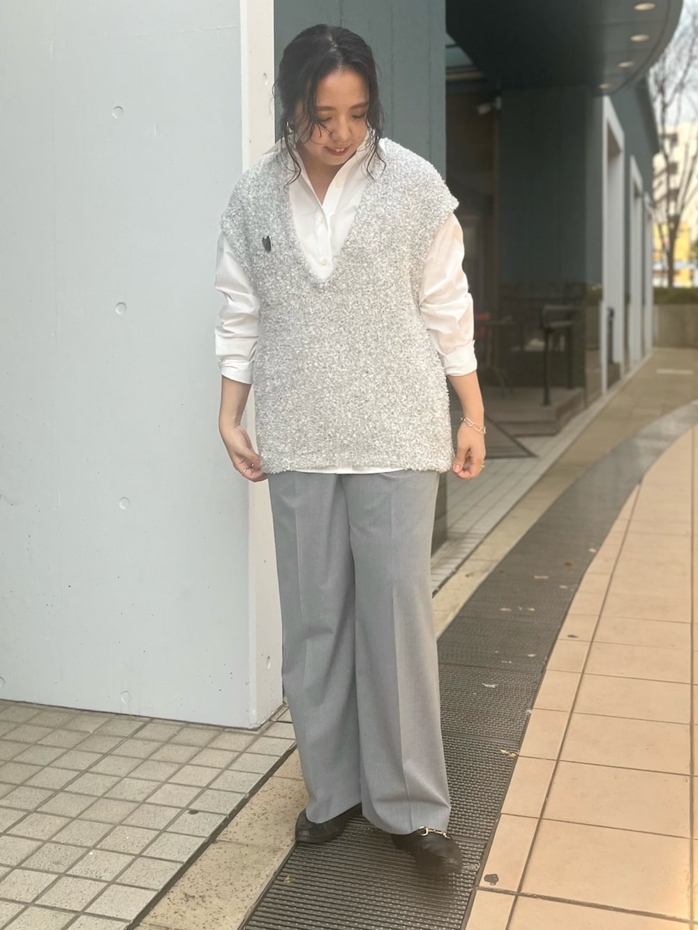 グレー系のベスト、ホワイト系のシャツ/ブラウス、グレー系のその他パンツを着用したレディースの冬コーディネートの7枚目の写真