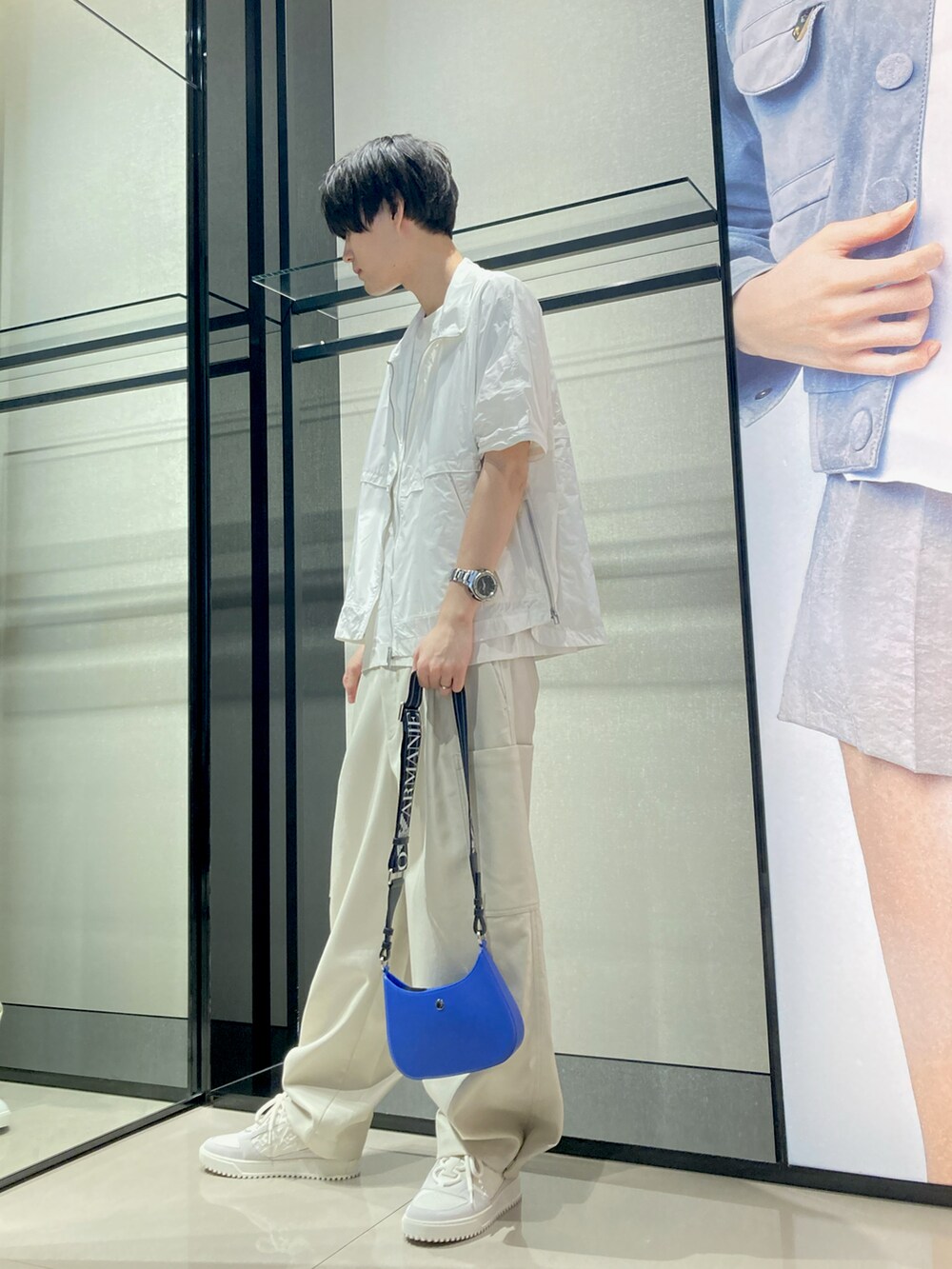 ホワイト系のTシャツ/カットソー、ホワイト系のナイロンジャケット、ブルー系のショルダーバッグを着用したメンズの夏コーディネートの3枚目の写真