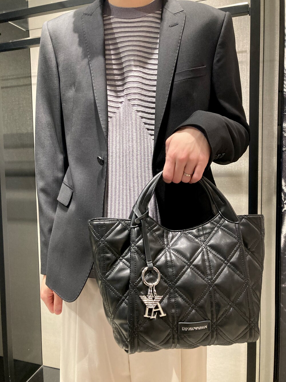 ブラック系のテーラードジャケット、グリーン系のニット/セーター、ホワイト系のスラックスを着用したメンズの冬コーディネートの2枚目の写真