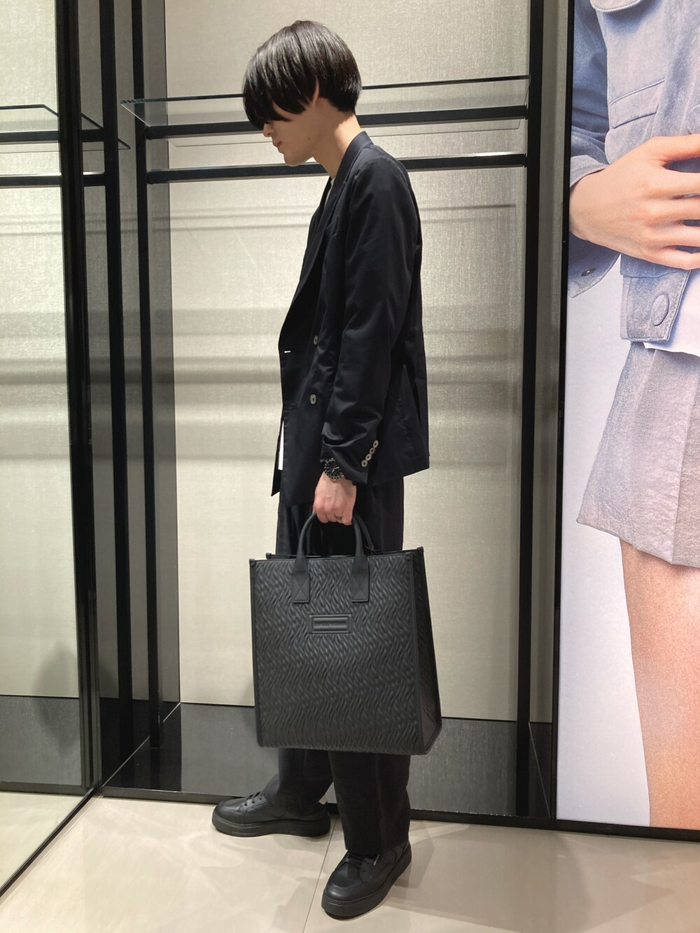 ホワイト系のTシャツ/カットソー、ブラック系のテーラードジャケット、ブラック系のスラックスを着用したメンズの春コーディネートの2枚目の写真