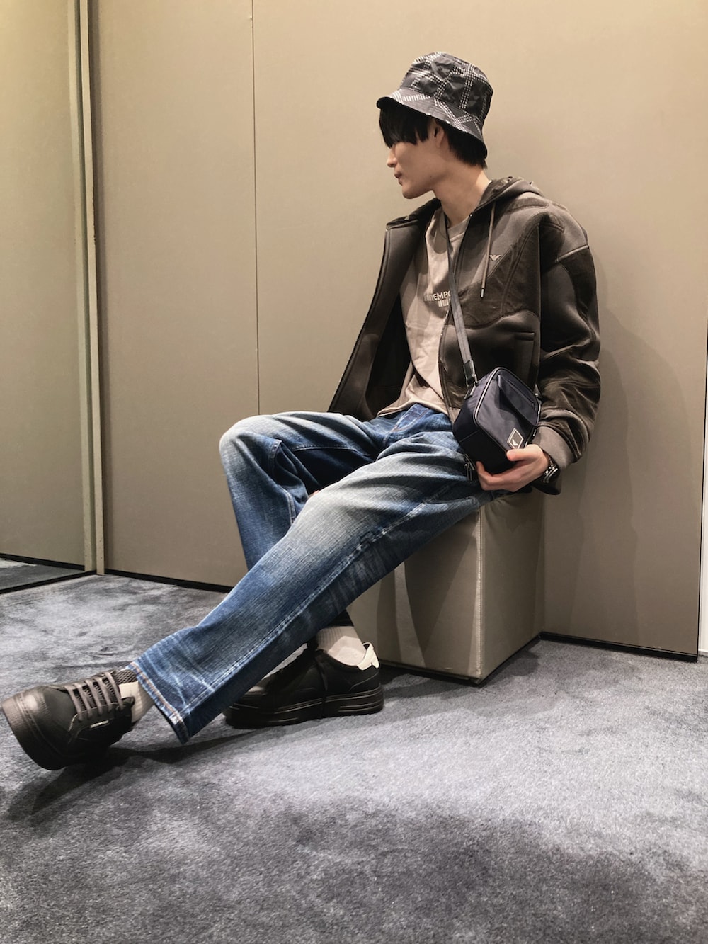 グリーン系のパーカー、ベージュ系のTシャツ/カットソー、ブルー系のショルダーバッグを着用したメンズの秋コーディネートの2枚目の写真