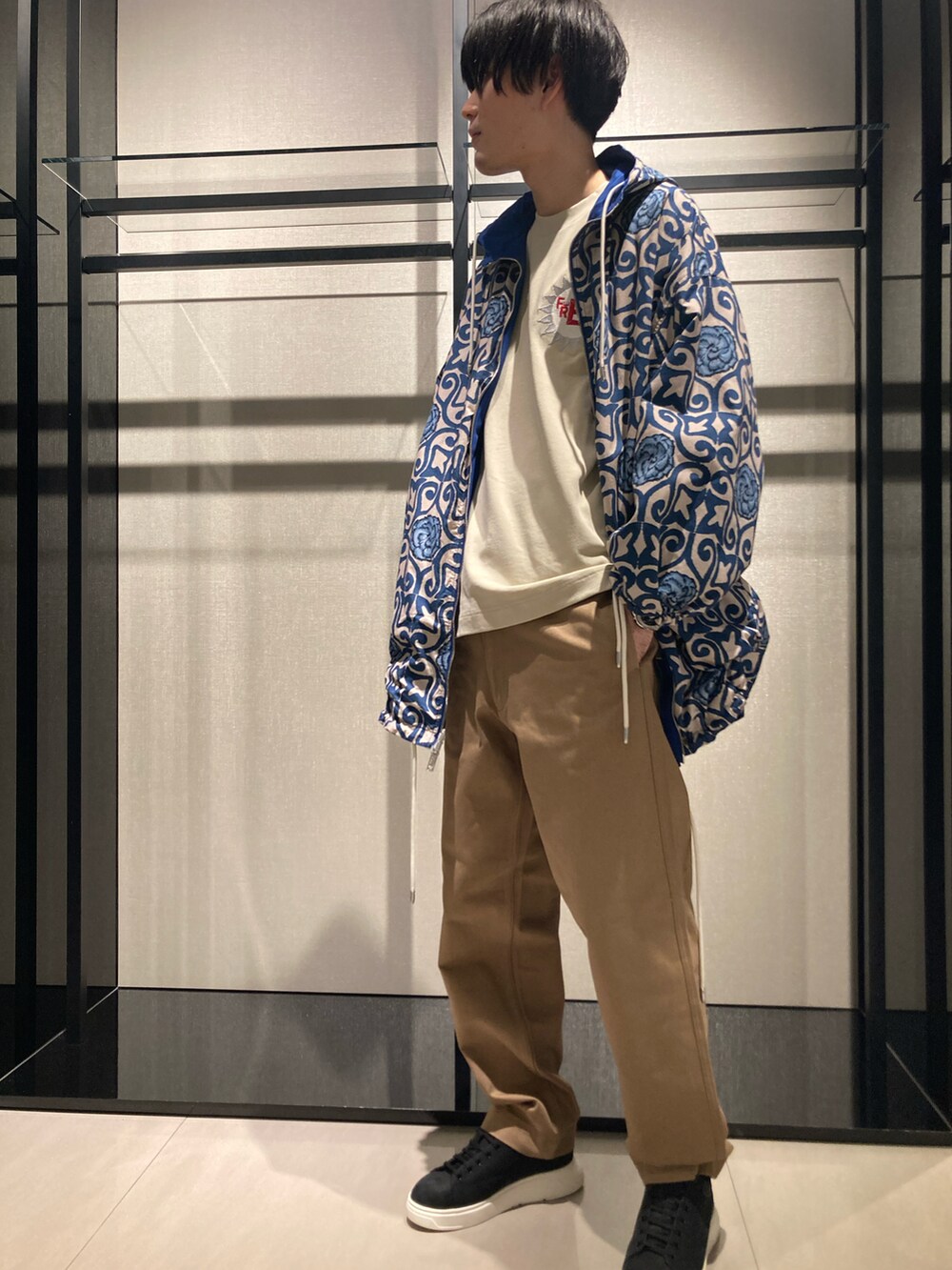 ブルー系のマウンテンパーカー、グレー系のトートバッグ、ベージュ系のパンツを着用したメンズの冬コーディネートの3枚目の写真