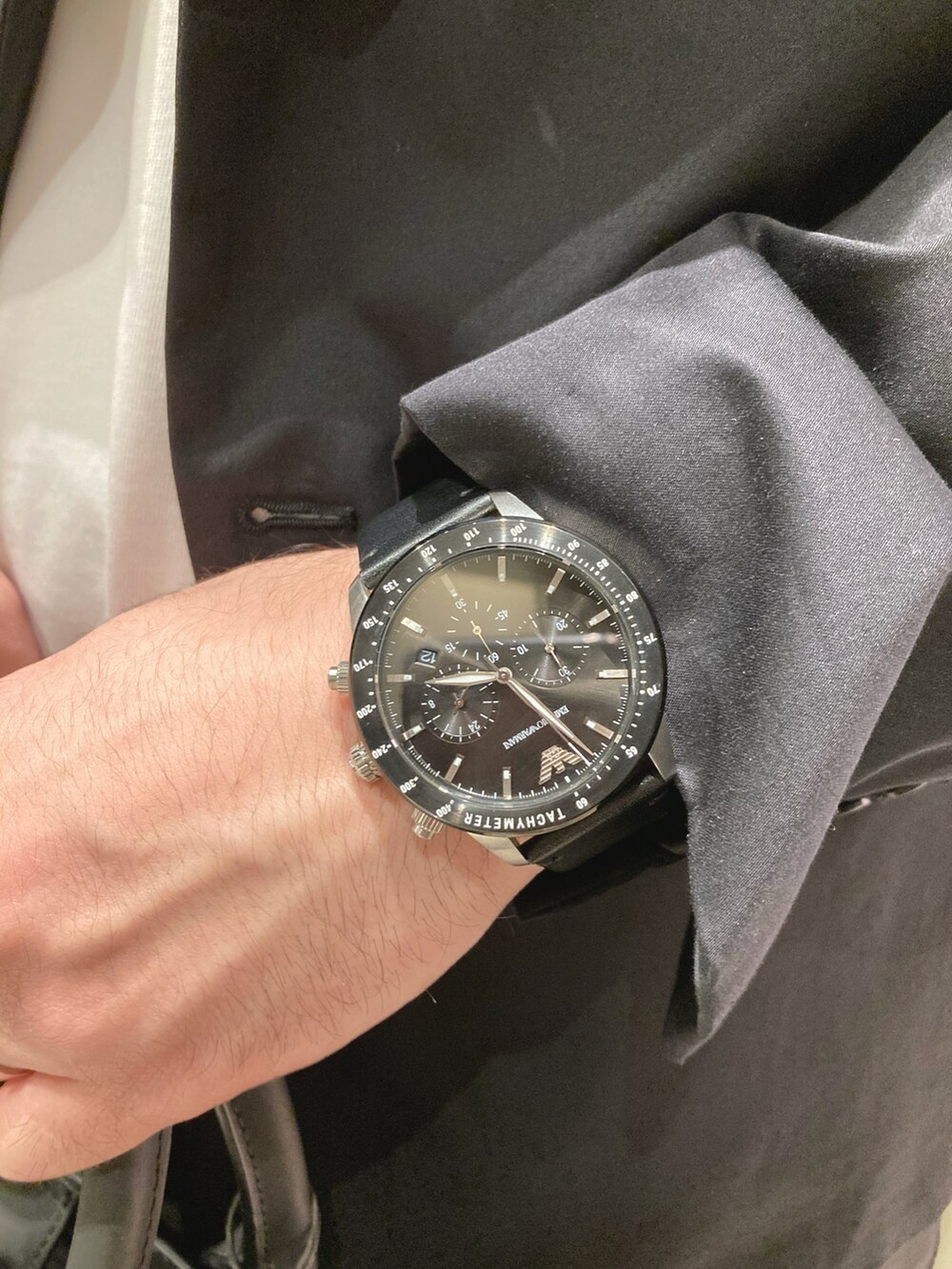 ホワイト系のTシャツ/カットソー、ブラック系のテーラードジャケット、ブラック系のスラックスを着用したメンズの春コーディネートの4枚目の写真