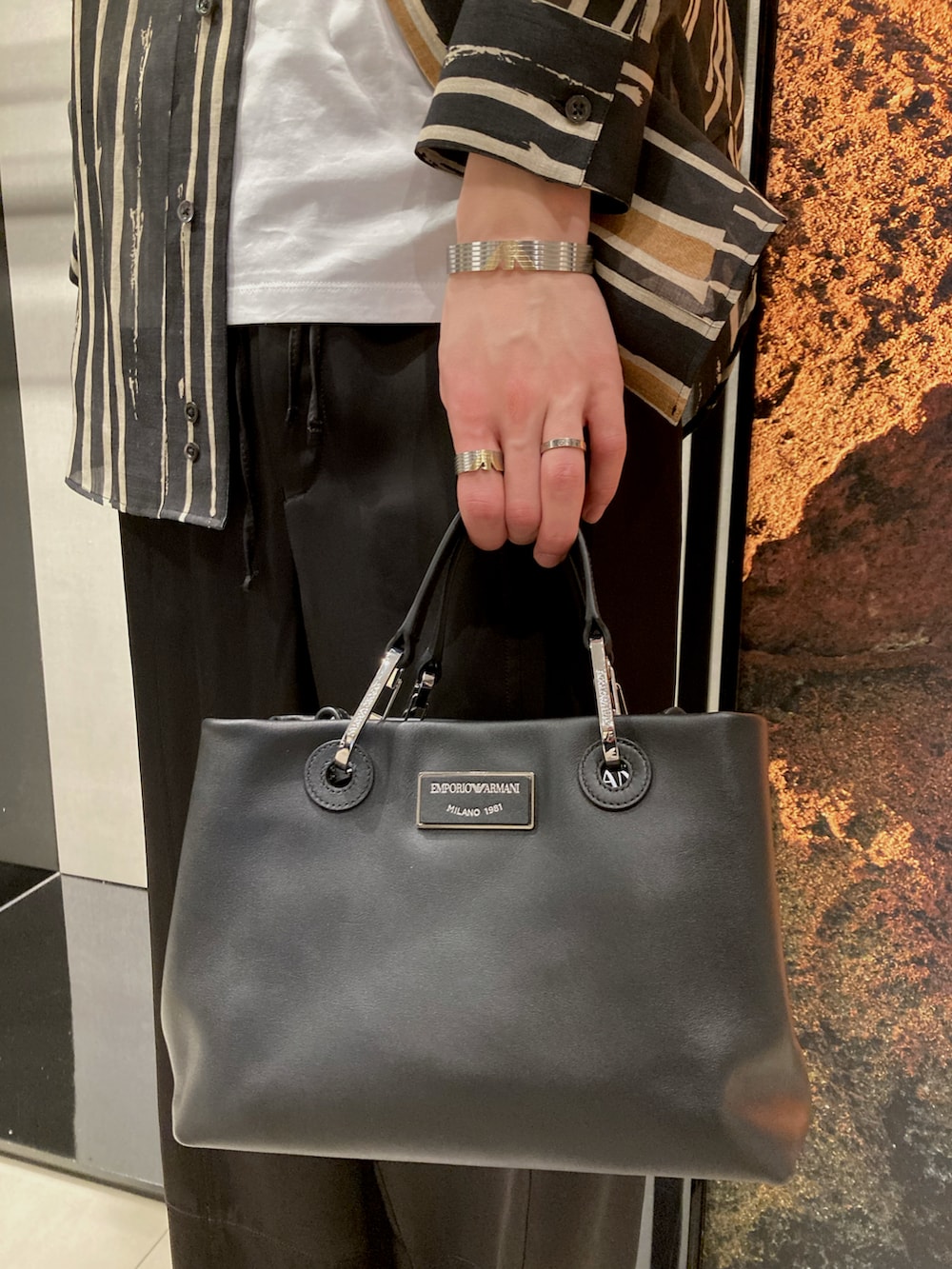 ブラック系のシャツ/ブラウス、ホワイト系のTシャツ/カットソー、ブラック系のスラックスを着用したメンズの春コーディネートの2枚目の写真