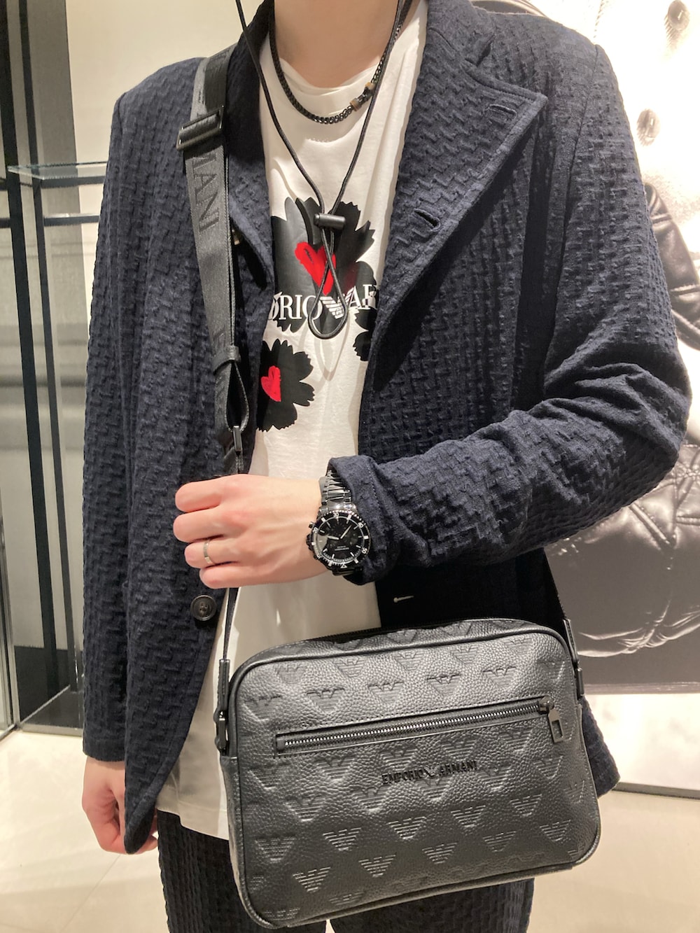 ブルー系のテーラードジャケット、ベージュ系のTシャツ/カットソー、ブラック系のショルダーバッグを着用したメンズの冬コーディネートの2枚目の写真