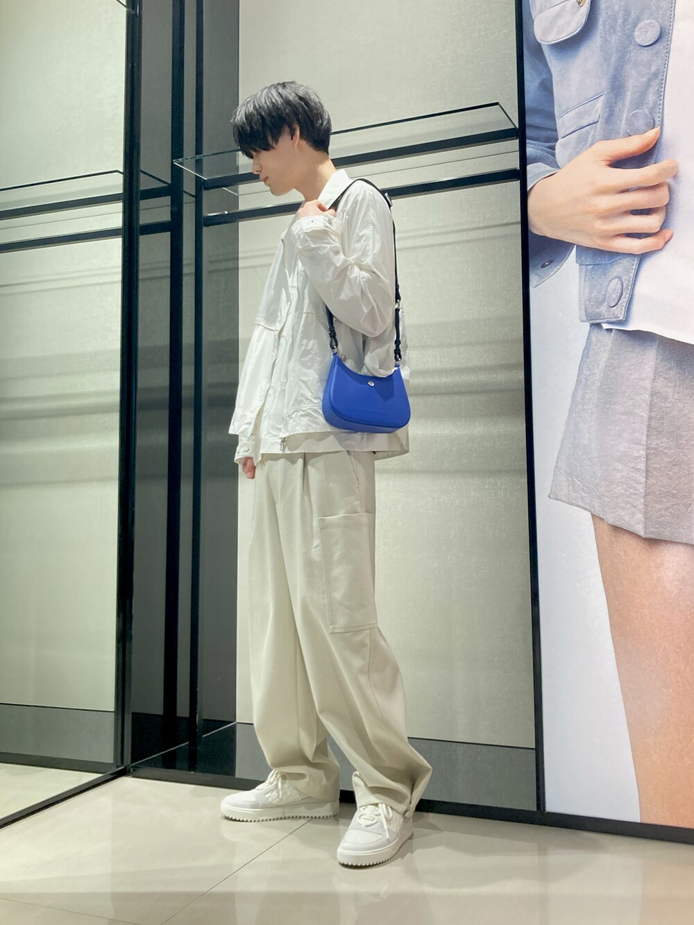 ホワイト系のTシャツ/カットソー、ホワイト系のナイロンジャケット、ブルー系のショルダーバッグを着用したメンズの夏コーディネートの2枚目の写真