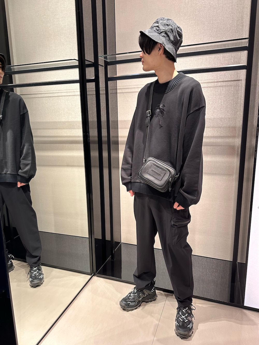 ブラック系のショルダーバッグ、ブラック系のスウェット、ブラック系のカーゴパンツを着用したメンズの春コーディネートの2枚目の写真