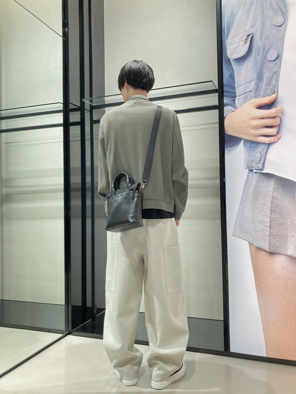 グリーン系のジャケット/アウター、ベージュ系のチノパンツ、ブラック系のスニーカーを着用したメンズの夏コーディネートの2枚目の写真