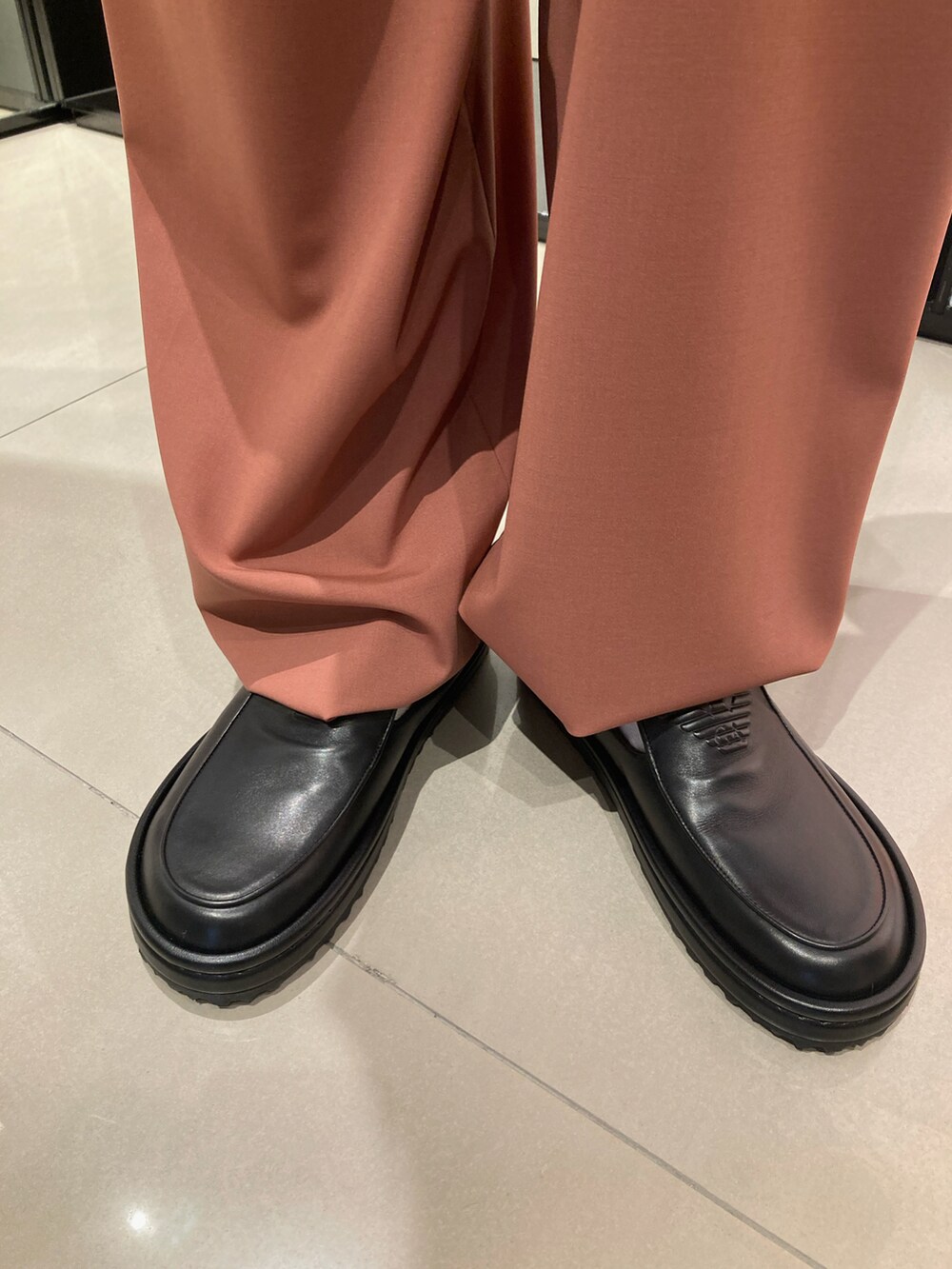 ブラック系のシャツ/ブラウス、ブラック系のハンドバッグ、オレンジ系のスラックスを着用したメンズの夏コーディネートの4枚目の写真