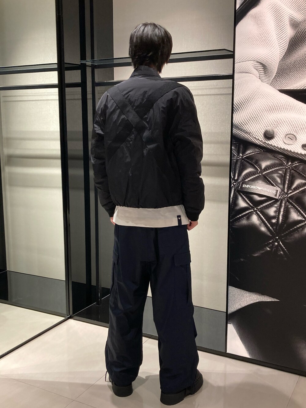 ブラック系のブルゾン、ホワイト系のTシャツ/カットソー、ブルー系のカーゴパンツを着用したメンズの秋コーディネートの4枚目の写真