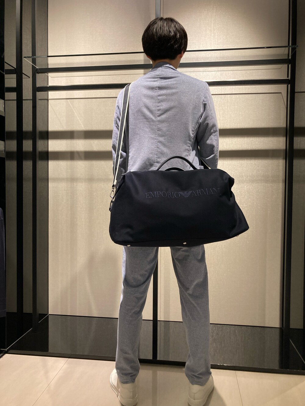 ブルー系のテーラードジャケット、ホワイト系のTシャツ/カットソー、ブラック系のボストンバッグを着用したメンズの冬コーディネートの2枚目の写真