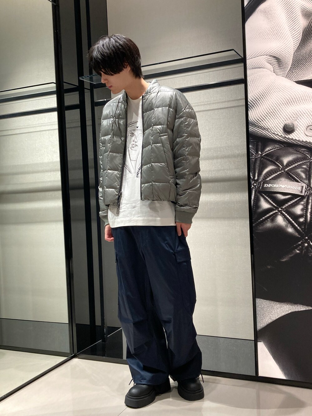 ブラック系のブルゾン、ホワイト系のTシャツ/カットソー、ブルー系のカーゴパンツを着用したメンズの秋コーディネートの3枚目の写真