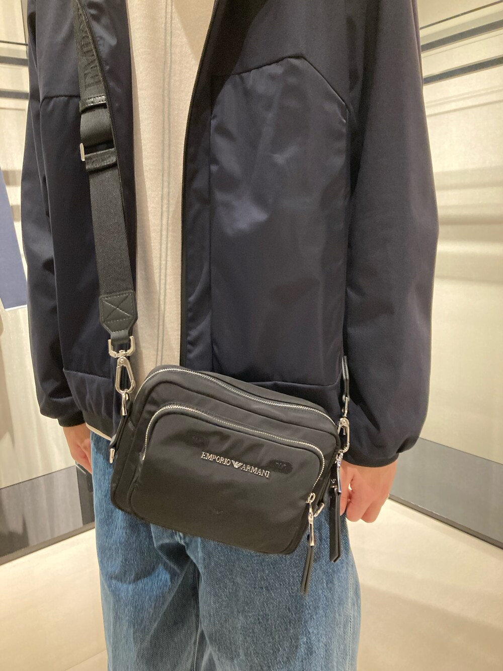 ブルー系のブルゾン、ブルー系のデニムパンツ、ベージュ系のニット/セーターを着用したメンズの秋コーディネートの2枚目の写真