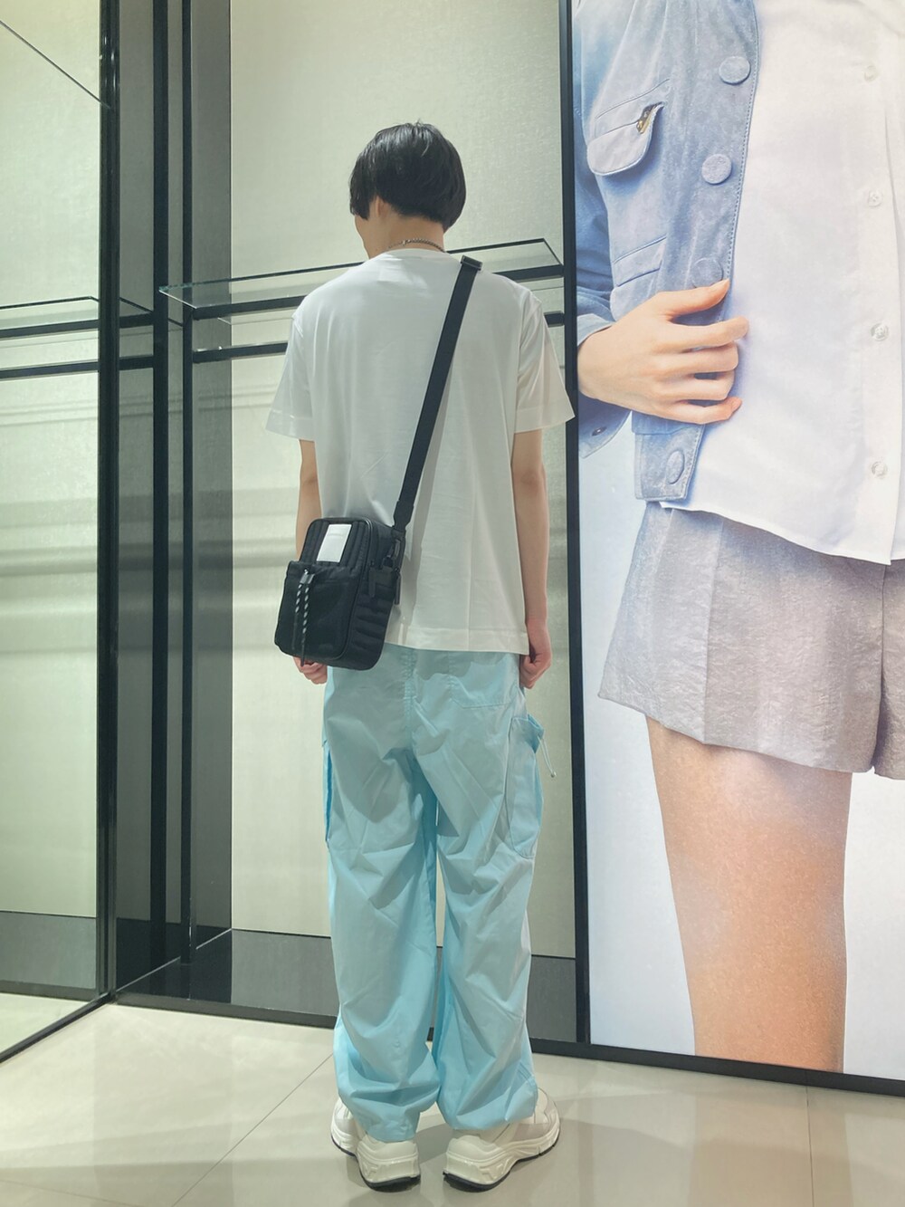 ホワイト系のTシャツ/カットソー、ブラック系のショルダーバッグ、ブルー系のカーゴパンツを着用したメンズの夏コーディネートの2枚目の写真