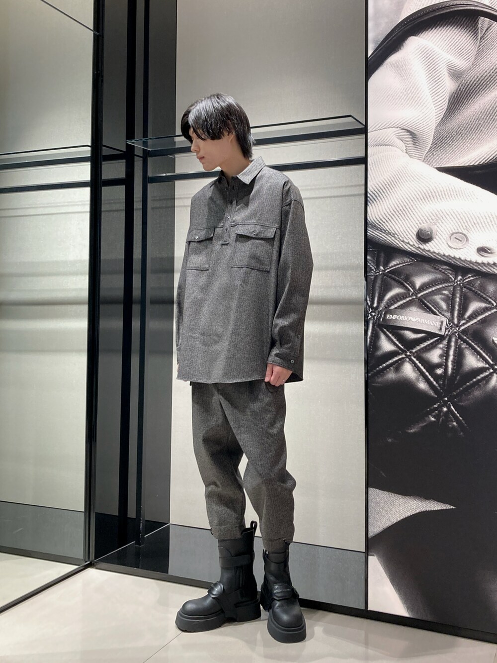 グレー系のテーラードジャケット、ブルー系のTシャツ/カットソー、ブラック系のショルダーバッグを着用したメンズの秋コーディネートの2枚目の写真