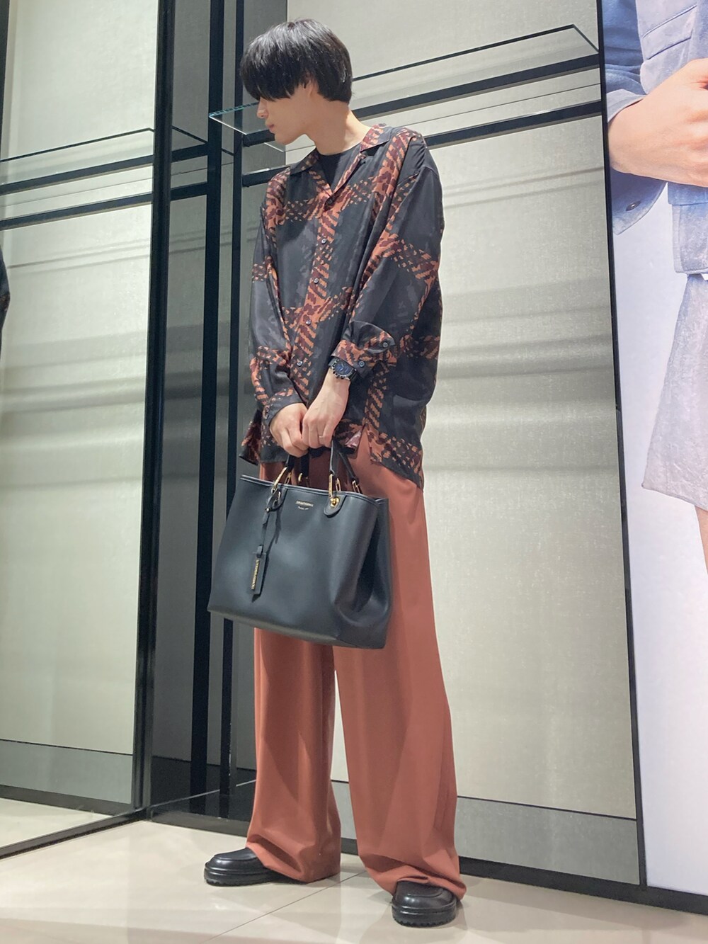 ブラック系のシャツ/ブラウス、ブラック系のハンドバッグ、オレンジ系のスラックスを着用したメンズの夏コーディネートの2枚目の写真