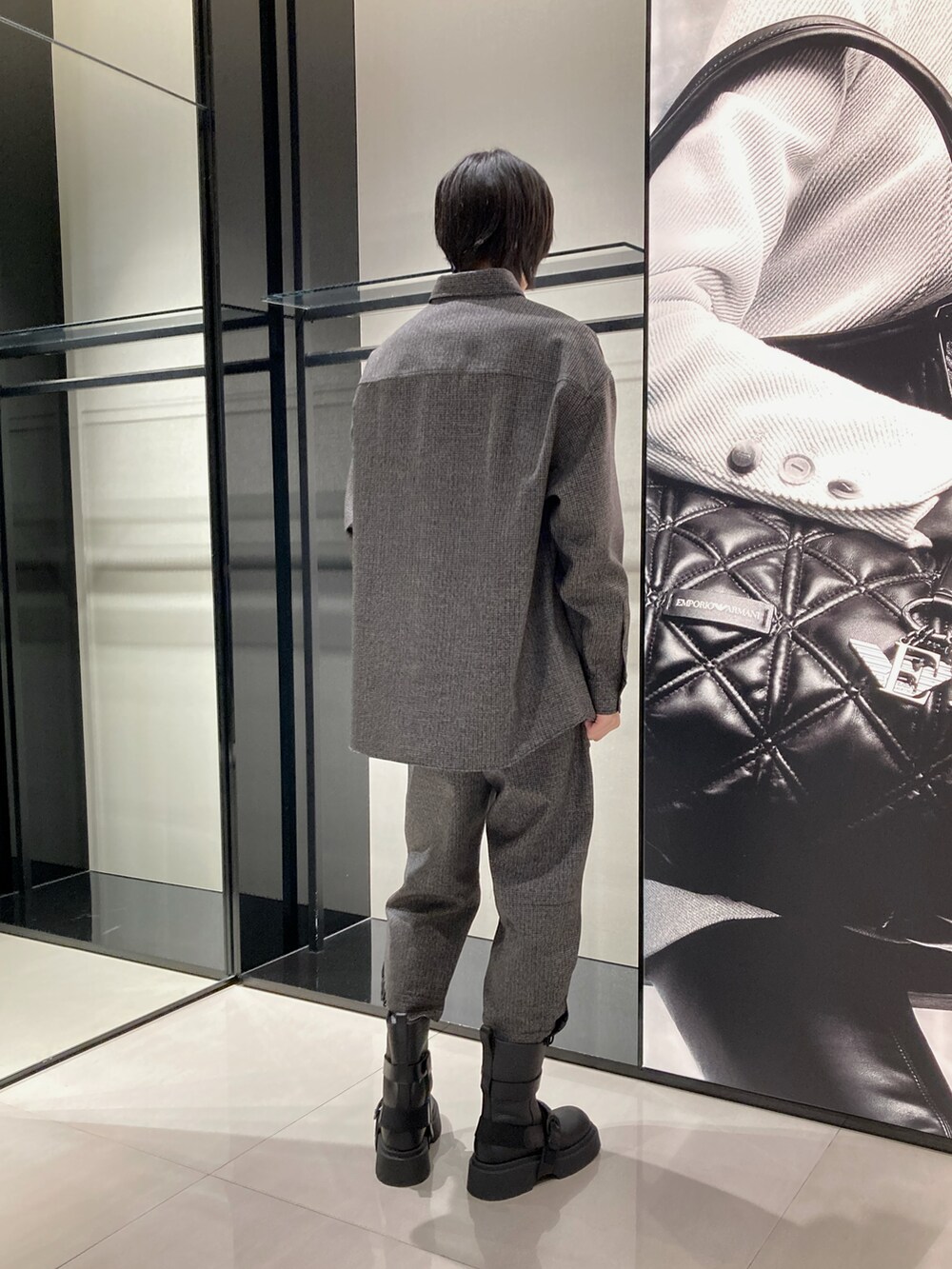 グレー系のテーラードジャケット、ブルー系のTシャツ/カットソー、ブラック系のショルダーバッグを着用したメンズの秋コーディネートの3枚目の写真