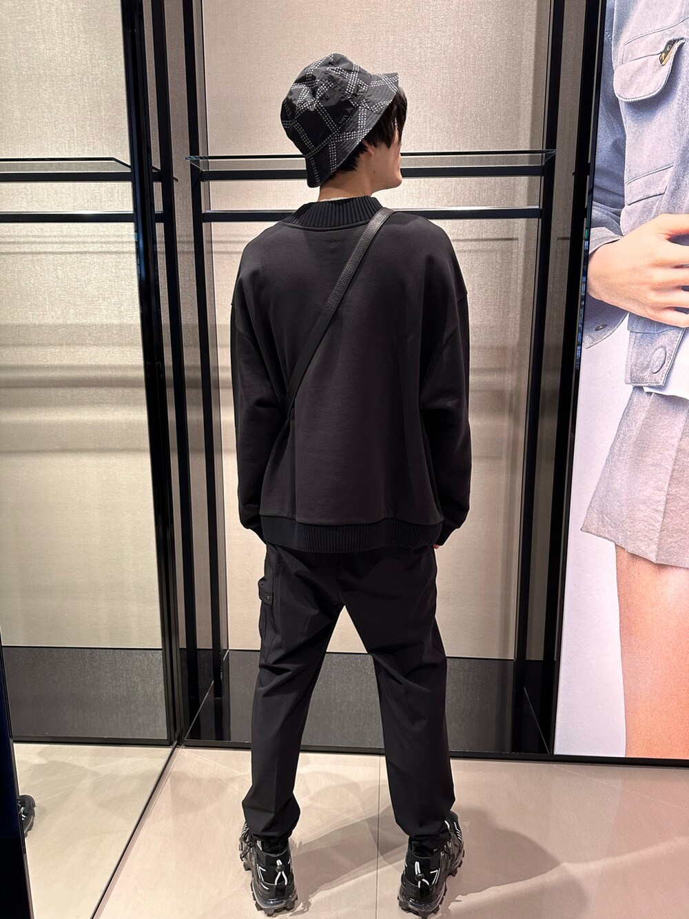 ブラック系のショルダーバッグ、ブラック系のスウェット、ブラック系のカーゴパンツを着用したメンズの春コーディネートの3枚目の写真