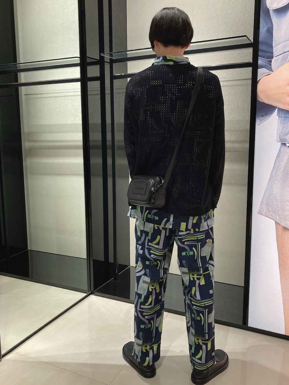 ブラック系のニット/セーター、イエロー系のシャツ/ブラウス、イエロー系のスラックスを着用したメンズの春コーディネートの3枚目の写真