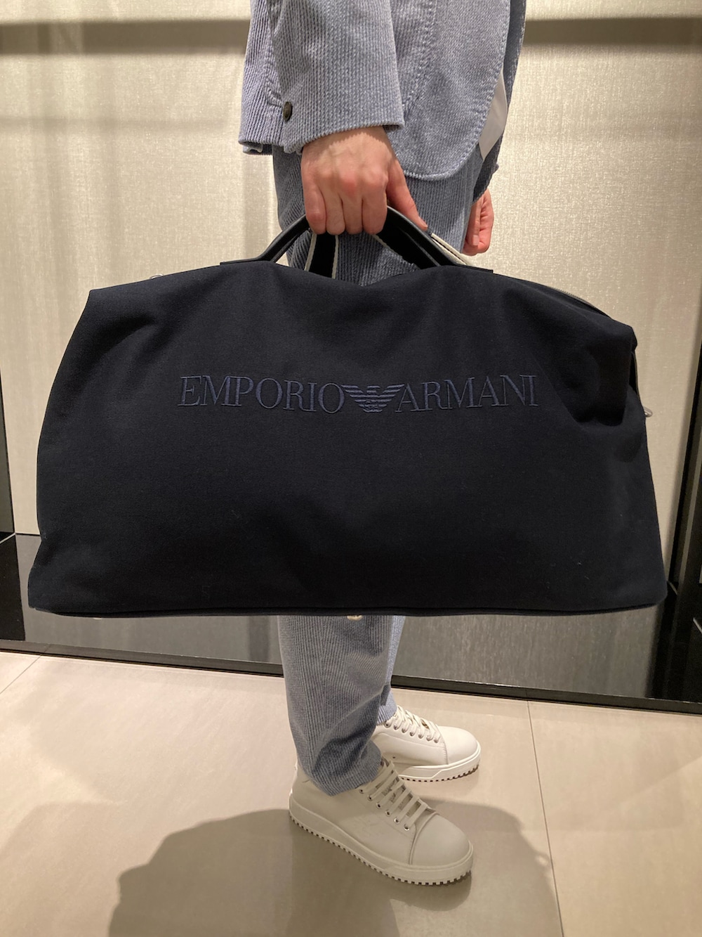 ブルー系のテーラードジャケット、ホワイト系のTシャツ/カットソー、ブラック系のボストンバッグを着用したメンズの冬コーディネートの3枚目の写真