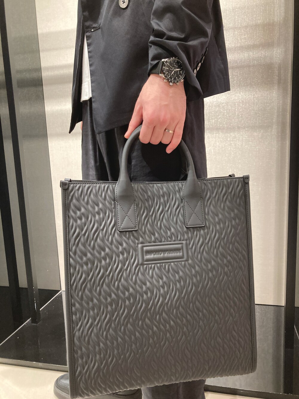 ホワイト系のTシャツ/カットソー、ブラック系のテーラードジャケット、ブラック系のスラックスを着用したメンズの春コーディネートの3枚目の写真