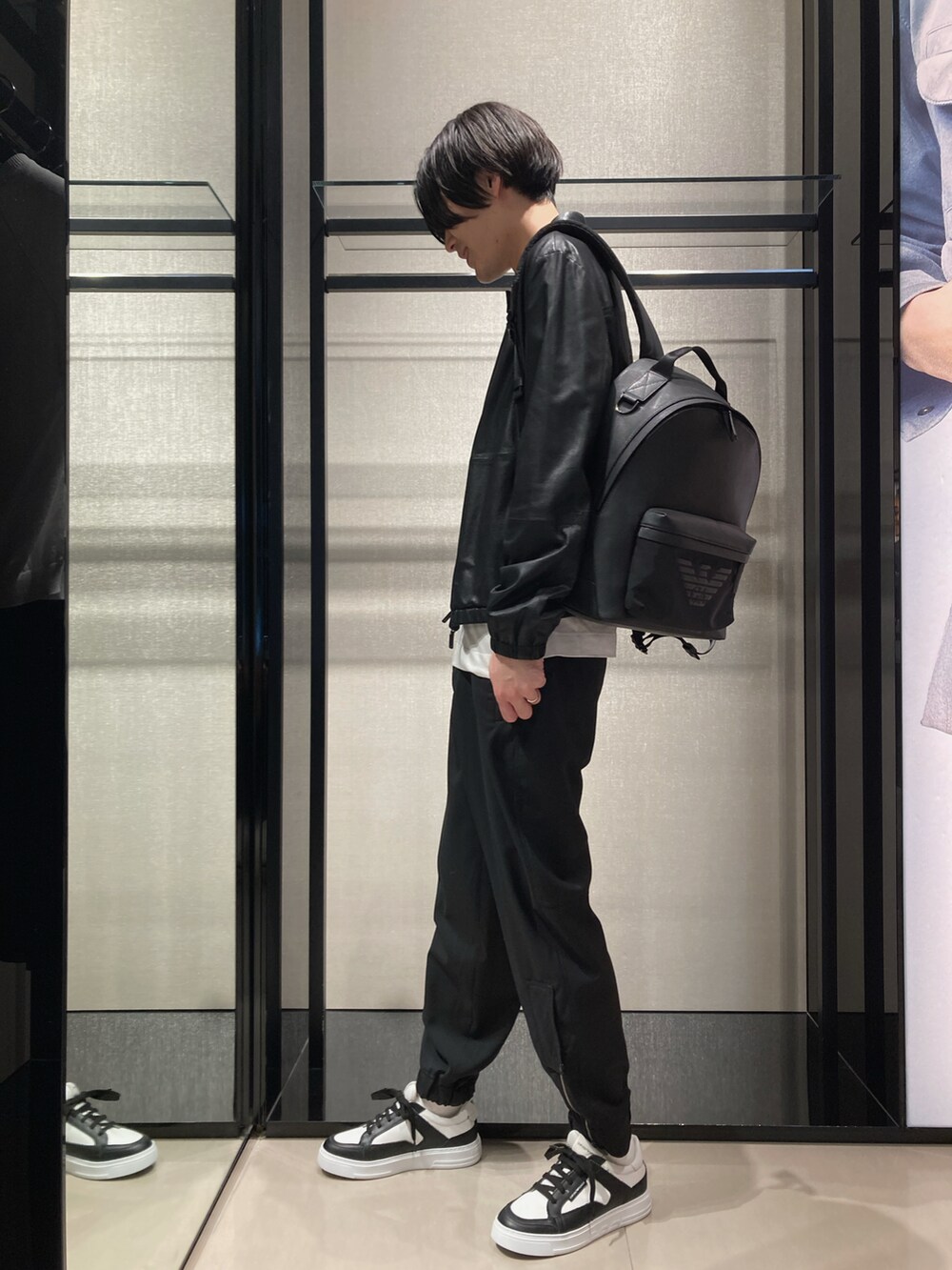 ホワイト系のTシャツ/カットソー、ブラック系のライダースジャケット、ブラック系のバックパック/リュックを着用したメンズの春コーディネートの2枚目の写真