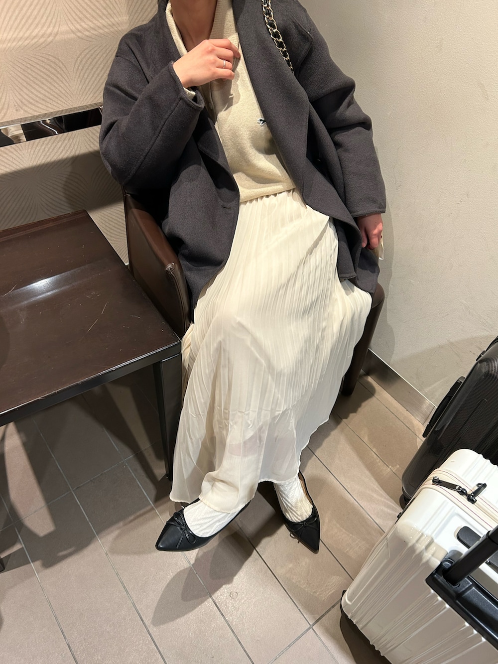 ベージュ系のニット/セーター、グレー系のノーカラーコート、ブラック系のパンプスを着用したレディースの冬コーディネートの2枚目の写真