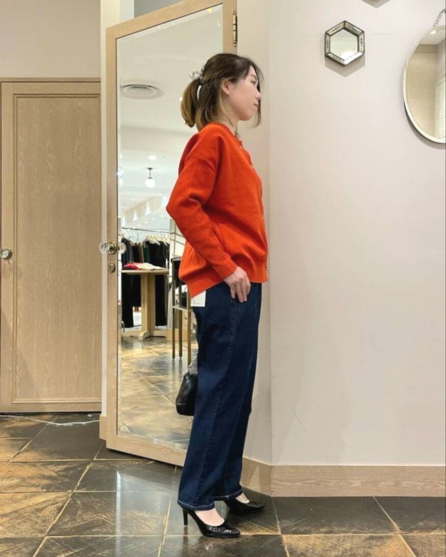 オレンジ系のカーディガン/ボレロ、ブルー系のデニムパンツ、ブラック系のショルダーバッグを着用したレディースの秋コーディネートの2枚目の写真