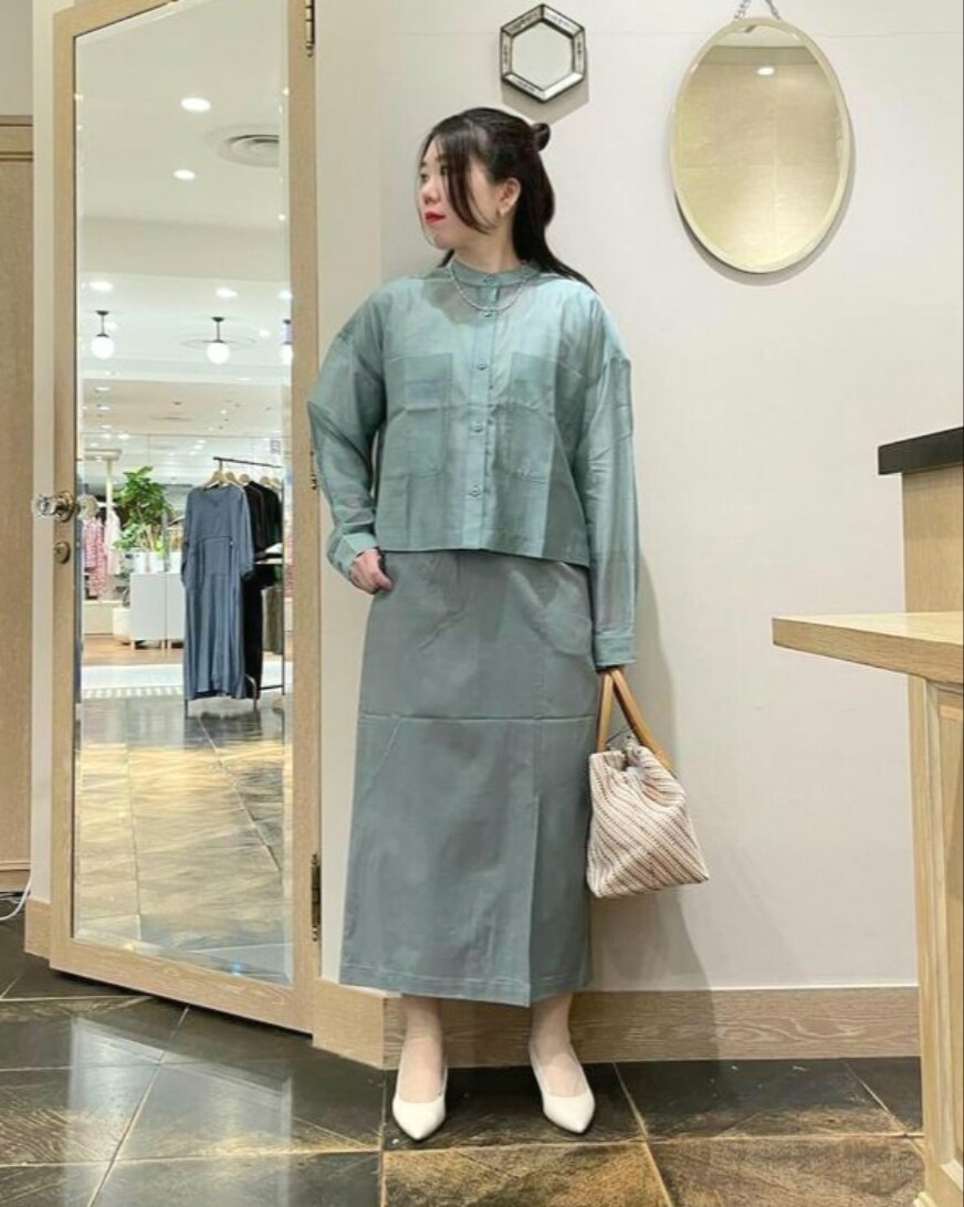 グリーン系のトップス、グリーン系のスカート、イエロー系のハンドバッグを着用したレディースの春コーディネートの2枚目の写真