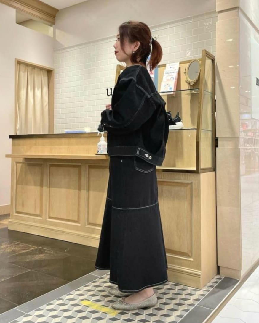 ホワイト系のニット/セーター、ブラック系のデニムジャケット、ブラック系のデニムスカートを着用したレディースの冬コーディネートの2枚目の写真