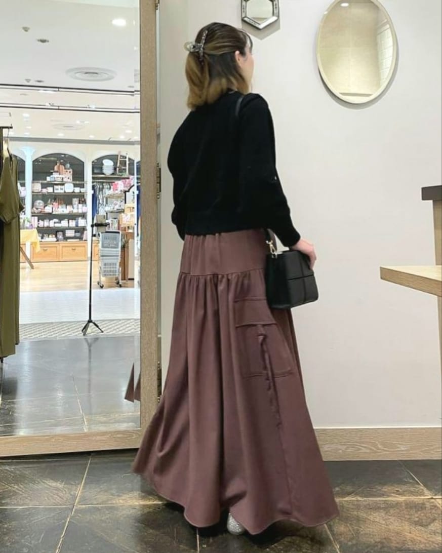 ブラック系のカーディガン/ボレロ、レッド系のスカート、ブラック系のハンドバッグを着用したレディースの秋コーディネートの2枚目の写真