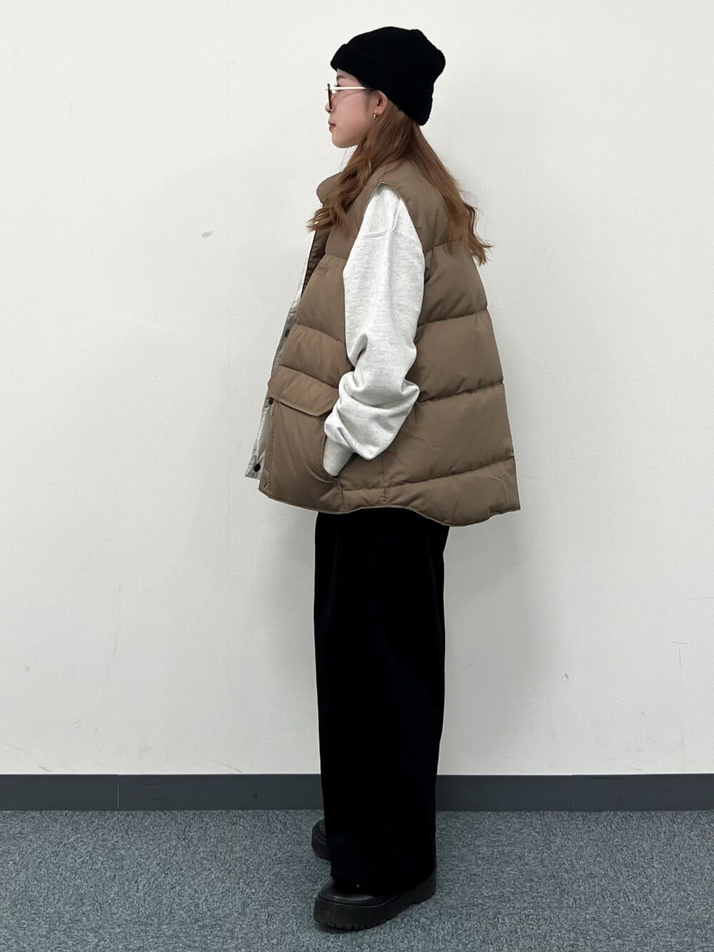 ホワイト系のスウェット、ベージュ系のダウンベスト、ブラック系のその他パンツを着用したレディースの冬コーディネートの4枚目の写真