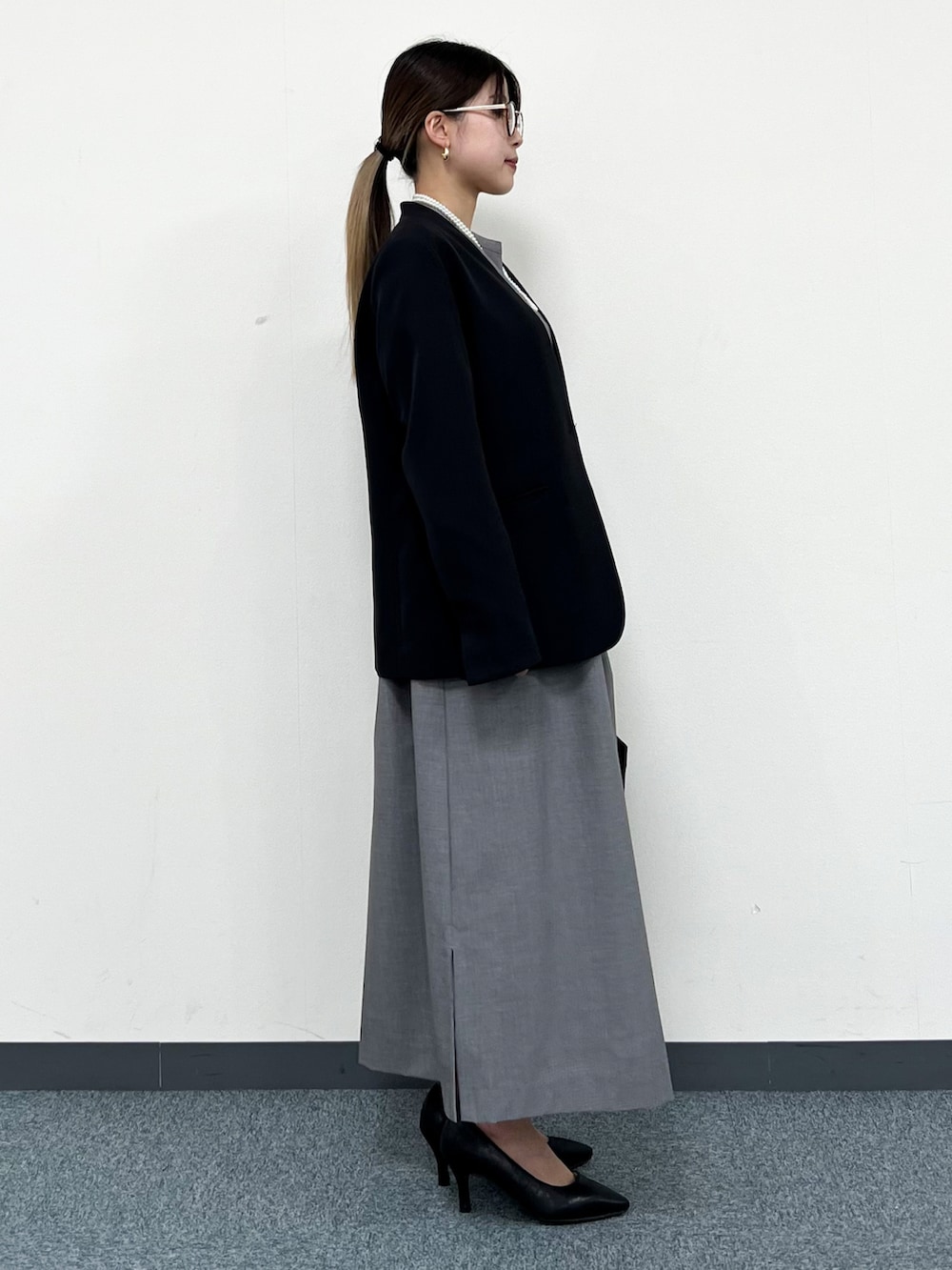 ブラック系のノーカラージャケット、グレー系のワンピース、ブラック系のトートバッグを着用したレディースの冬コーディネートの2枚目の写真