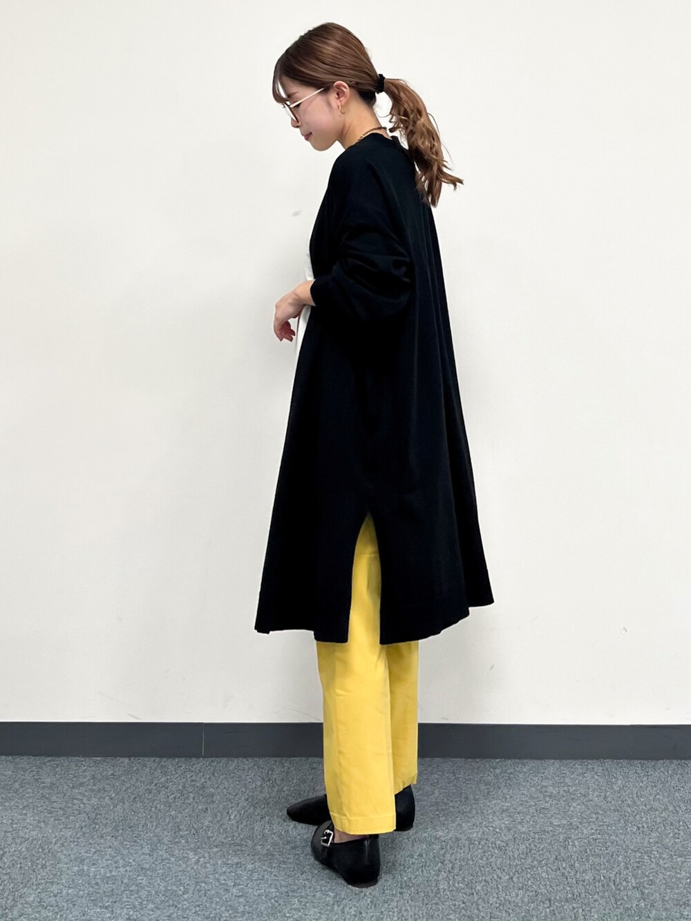 ブラック系のカーディガン/ボレロ、ホワイト系のTシャツ/カットソー、イエロー系のその他パンツを着用したレディースの冬コーディネートの4枚目の写真