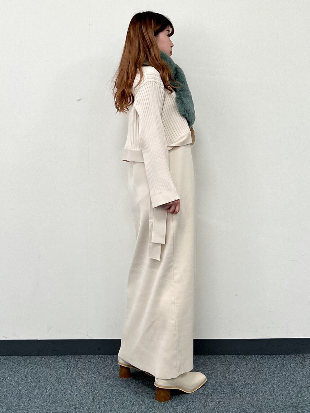 ベージュ系のワンピース、ベージュ系のブーツ、グリーン系のストール/ショールを着用したレディースの冬コーディネートの2枚目の写真