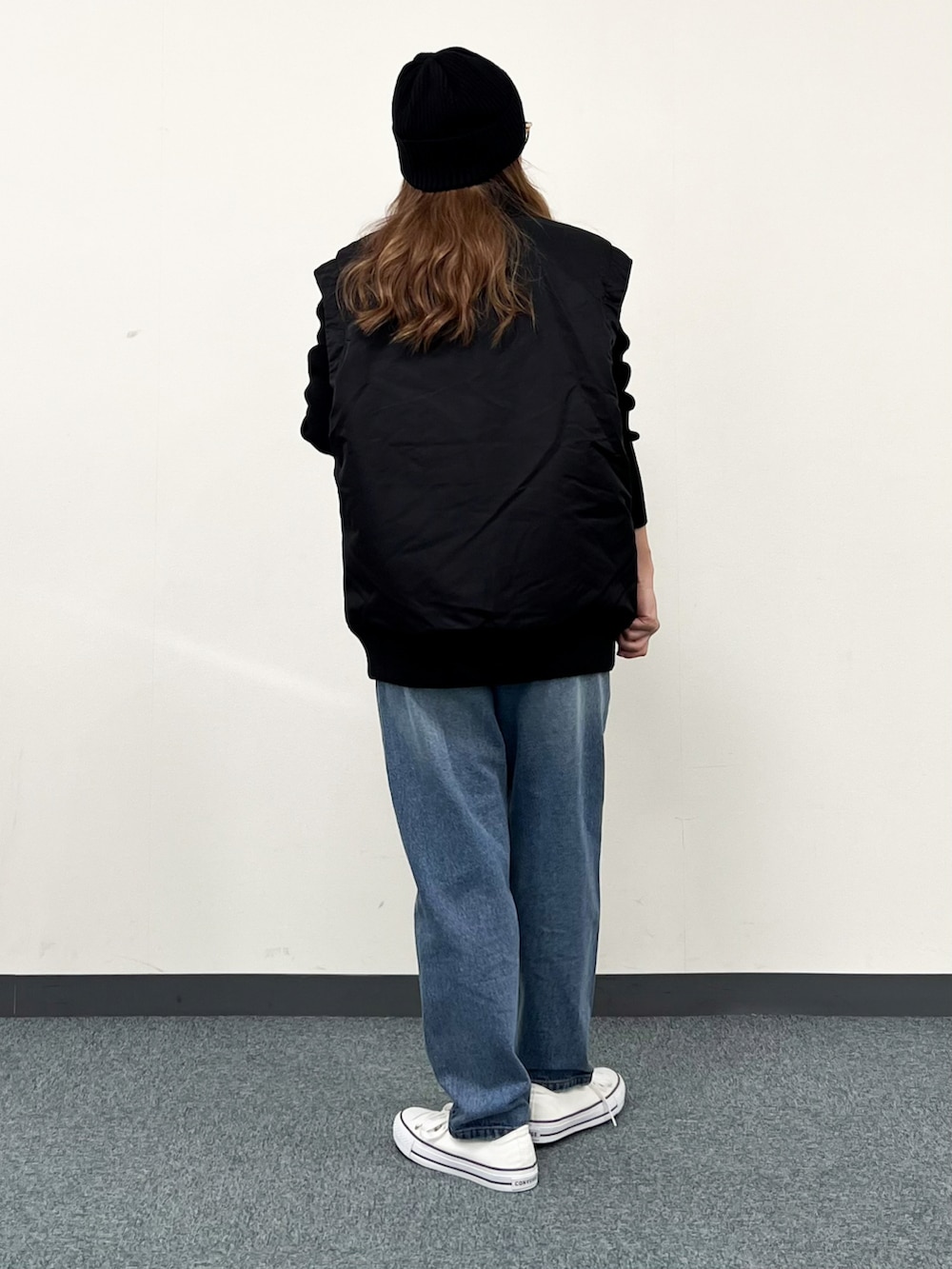 ブラック系のブルゾン、ブラック系のニット/セーター、ブルー系のその他パンツを着用したレディースの冬コーディネートの2枚目の写真