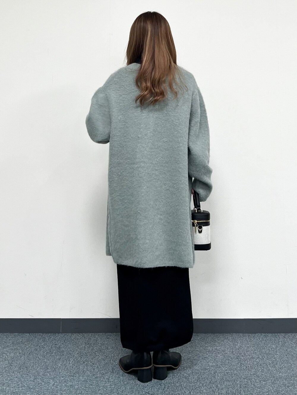 グリーン系のカーディガン/ボレロ、ブラック系のショルダーバッグ、ブラック系のワンピースを着用したレディースの冬コーディネートの3枚目の写真