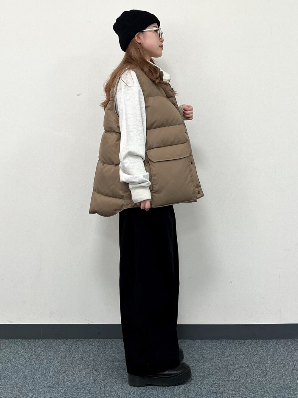 ホワイト系のスウェット、ベージュ系のダウンベスト、ブラック系のその他パンツを着用したレディースの冬コーディネートの2枚目の写真