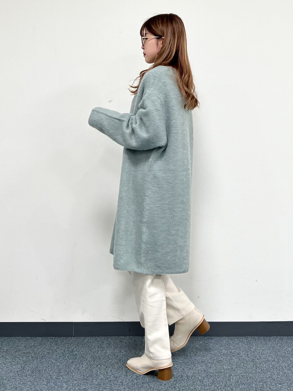 グリーン系のカーディガン/ボレロ、ベージュ系のハンドバッグ、ホワイト系のその他パンツを着用したレディースの冬コーディネートの4枚目の写真