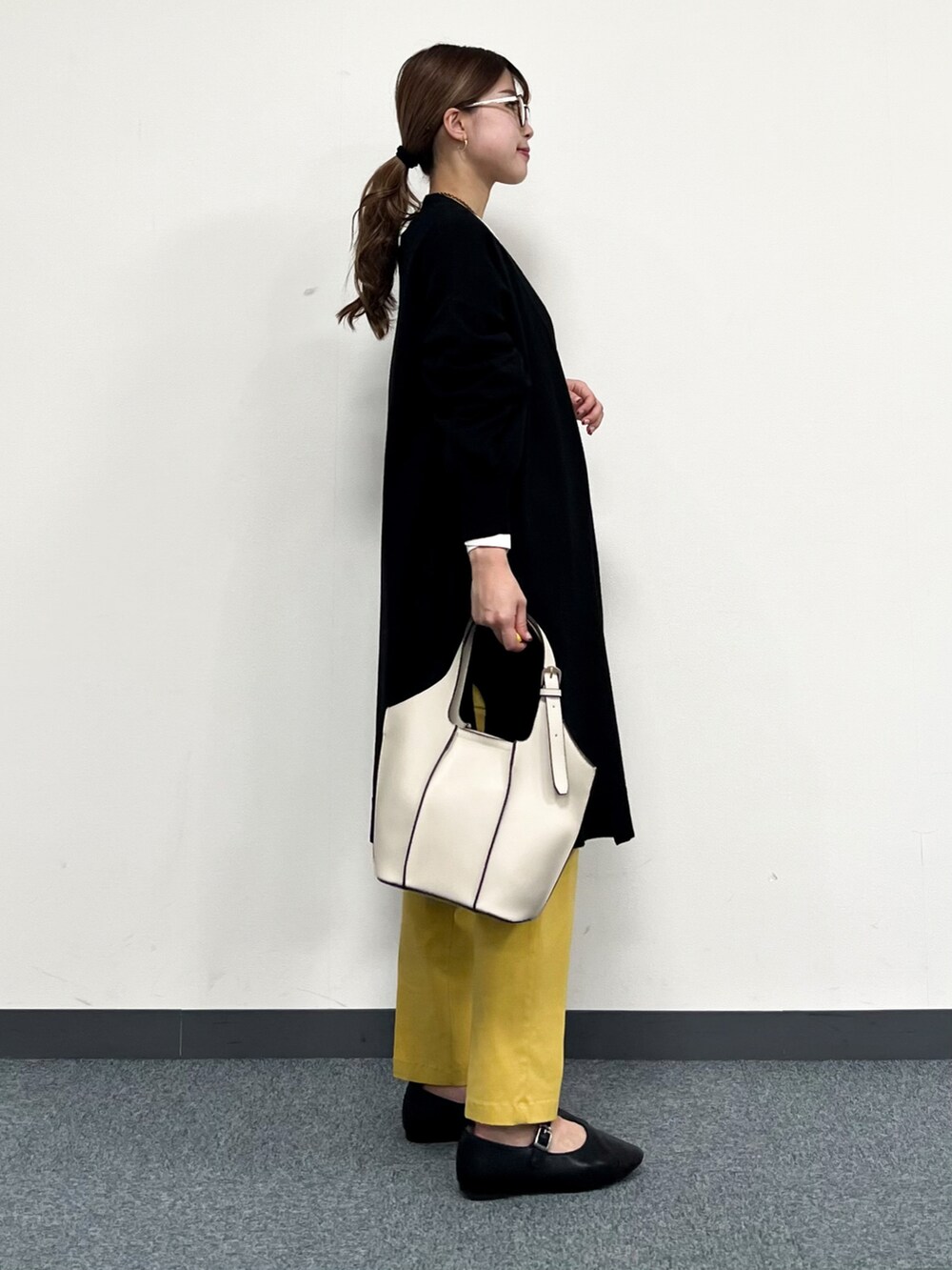 ブラック系のカーディガン/ボレロ、ホワイト系のTシャツ/カットソー、イエロー系のその他パンツを着用したレディースの冬コーディネートの2枚目の写真