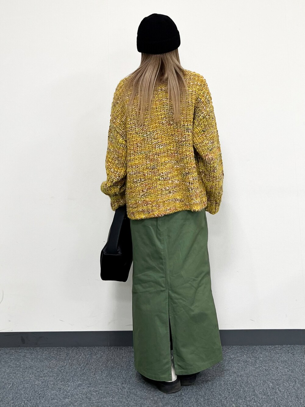 ホワイト系のTシャツ/カットソー、イエロー系のカーディガン/ボレロ、ブラック系のトートバッグを着用したレディースの冬コーディネートの3枚目の写真