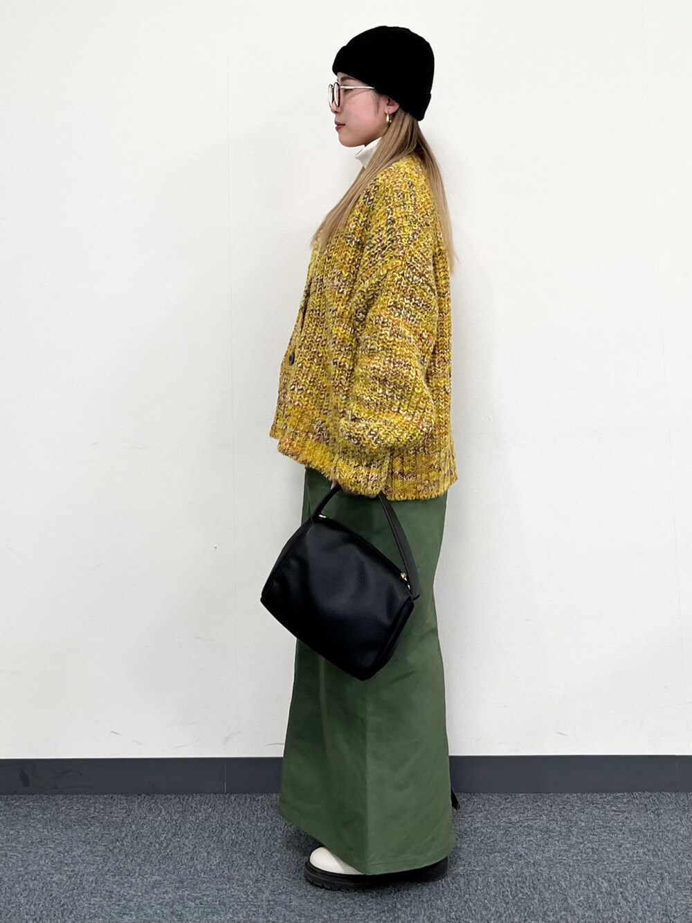 ホワイト系のTシャツ/カットソー、イエロー系のカーディガン/ボレロ、ブラック系のトートバッグを着用したレディースの冬コーディネートの4枚目の写真