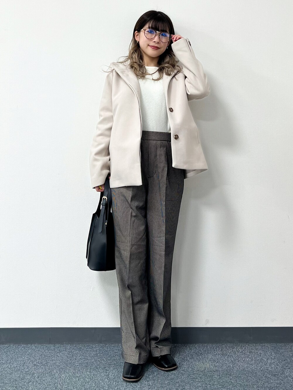 ベージュ系のその他アウター、ホワイト系のニット/セーター、ブラック系のトートバッグを着用したレディースの冬コーディネートの2枚目の写真