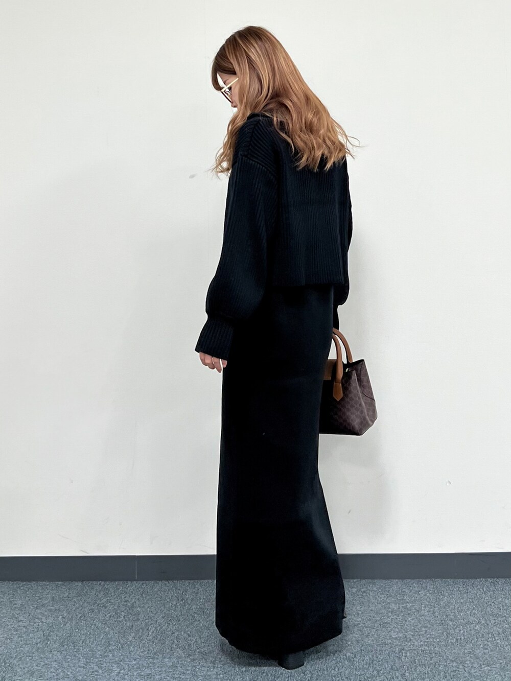 ブラック系のワンピース、ブラウン系のショルダーバッグ、ブラック系のブーツを着用したレディースの冬コーディネートの4枚目の写真