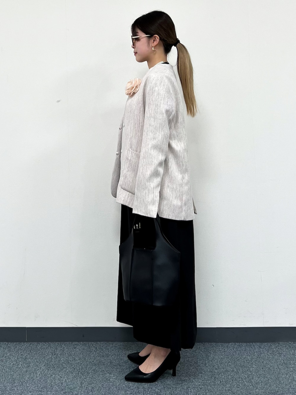 ベージュ系のノーカラージャケット、ブラック系のワンピース、ブラック系のトートバッグを着用したレディースの冬コーディネートの4枚目の写真