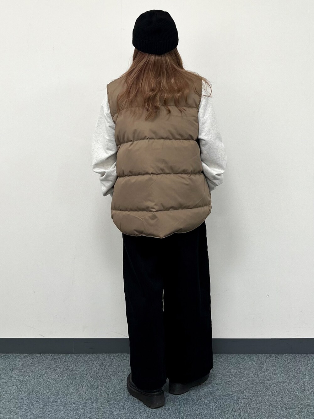 ホワイト系のスウェット、ベージュ系のダウンベスト、ブラック系のその他パンツを着用したレディースの冬コーディネートの3枚目の写真