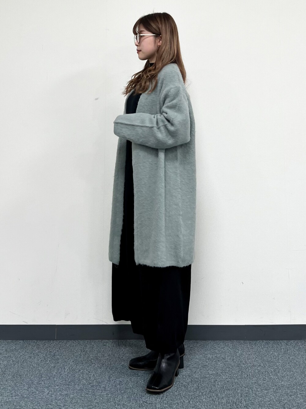 グリーン系のカーディガン/ボレロ、ブラック系のショルダーバッグ、ブラック系のワンピースを着用したレディースの冬コーディネートの4枚目の写真